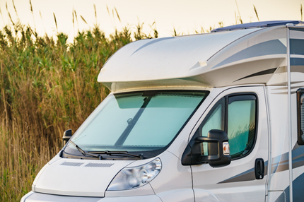 A motorhome with blinds in the front window