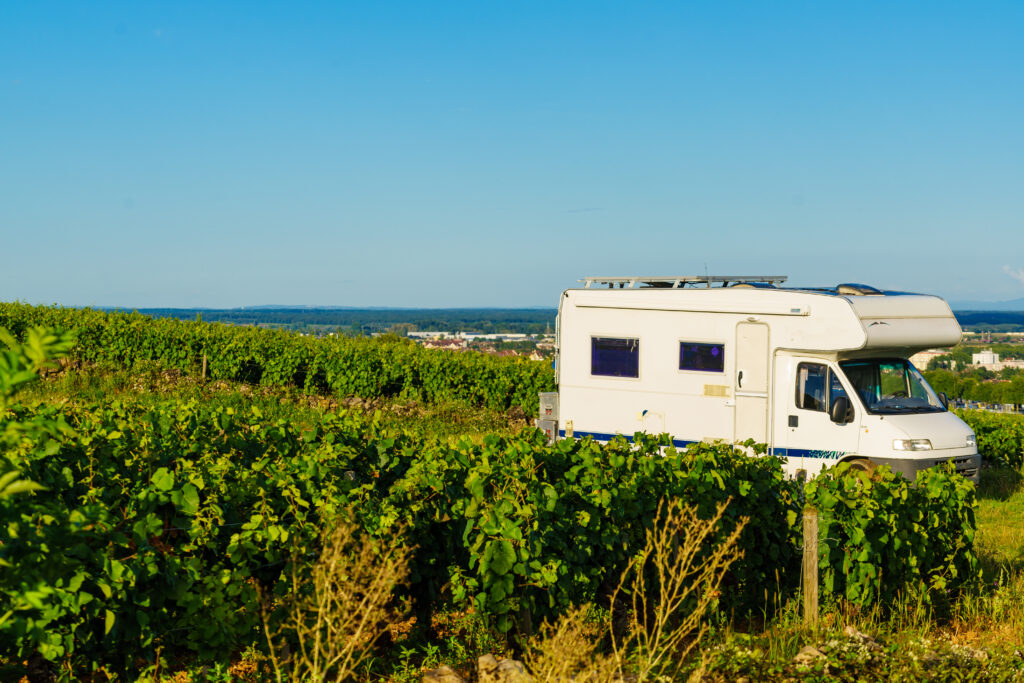 A motorhome in a field with blue sky