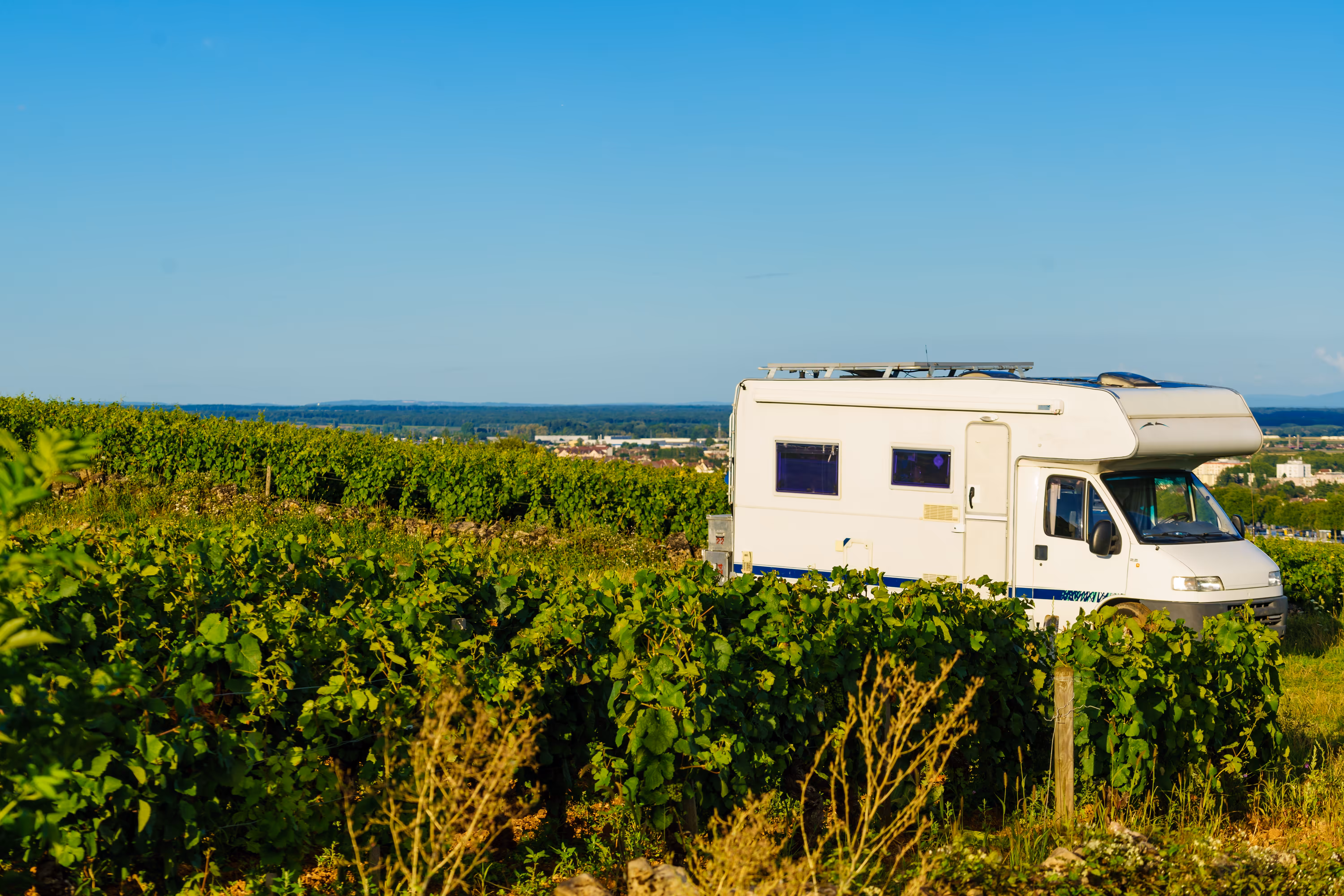 A motorhome in a field with blue sky