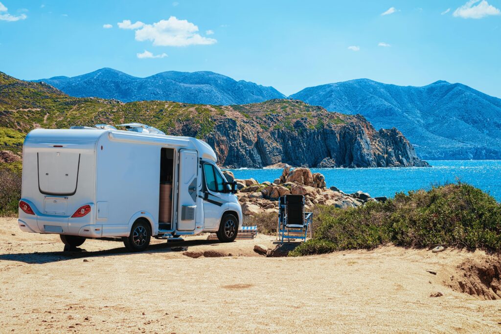 Motorhome parked on a rocky coastline in summer weather