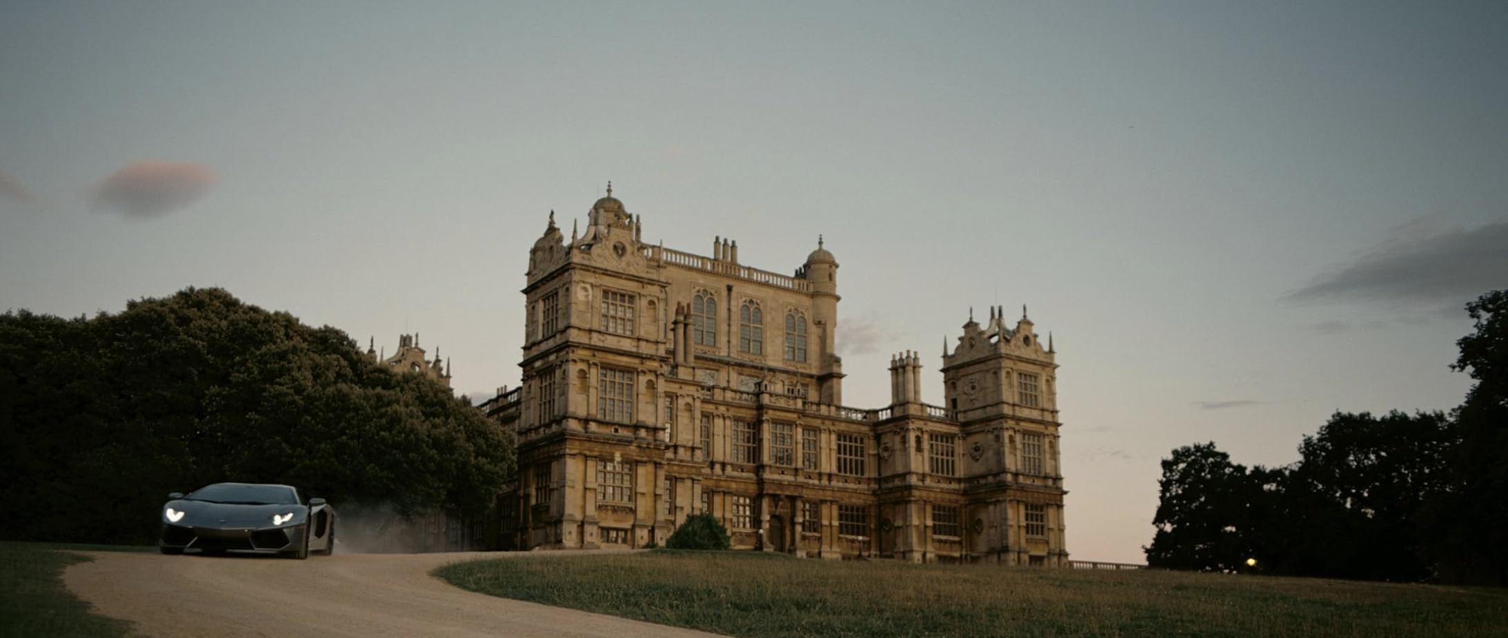 A massive estate in England with a car coming out the drive way