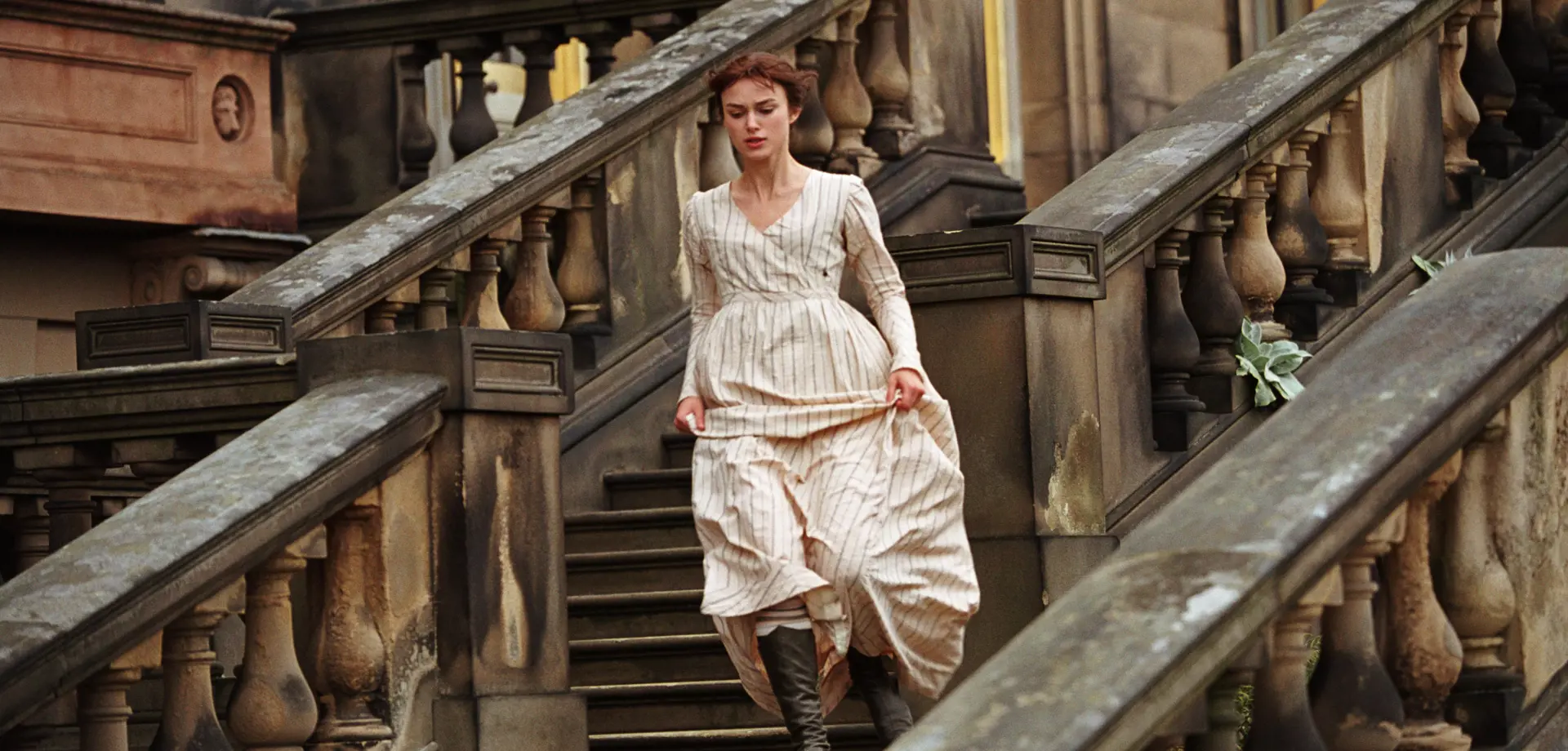 A woman in a white dress running down stairs