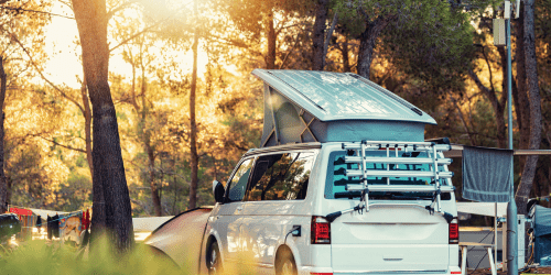 A white campervan parked in a forest
